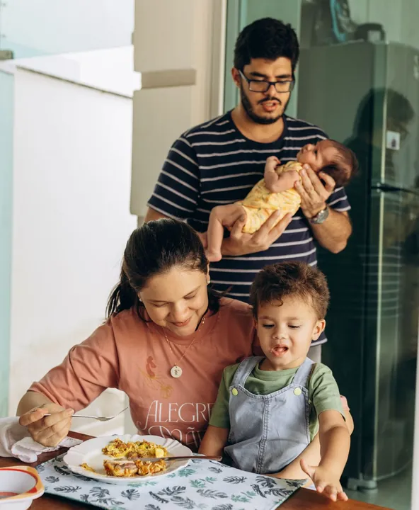 Família reunida à mesa com um bebê