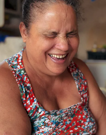 Mulher sorrindo, de olhos fechados